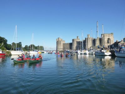 Canoeing journey on a trip down Menai Straits with castle view.