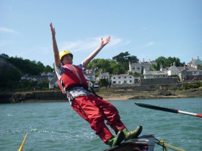 Jumping from canoe on Outdoor activity course in Menai Straits