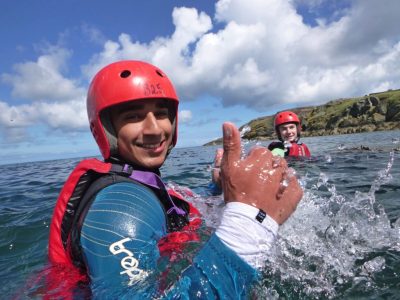Swimming outdoors while coasteering around sea cliffs on Anglesey
