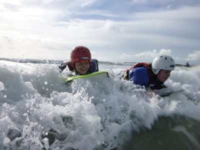 Outdoor education course body boarding in surf